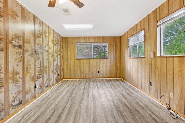12 Walker Trl, Huntsville, TX 77320 - empty room with wood finished floors, plenty of natural light, a ceiling fan, wooden walls, and baseboards