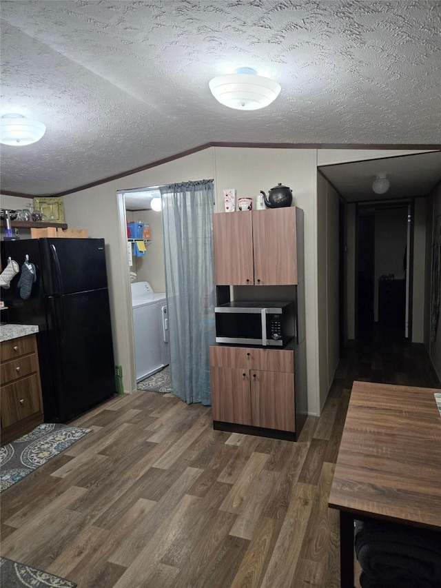 100 St Croix Dr, Point Blank, TX 77364 - kitchen featuring washer / dryer, stainless steel microwave, freestanding refrigerator, dark wood-style flooring, and a textured ceiling