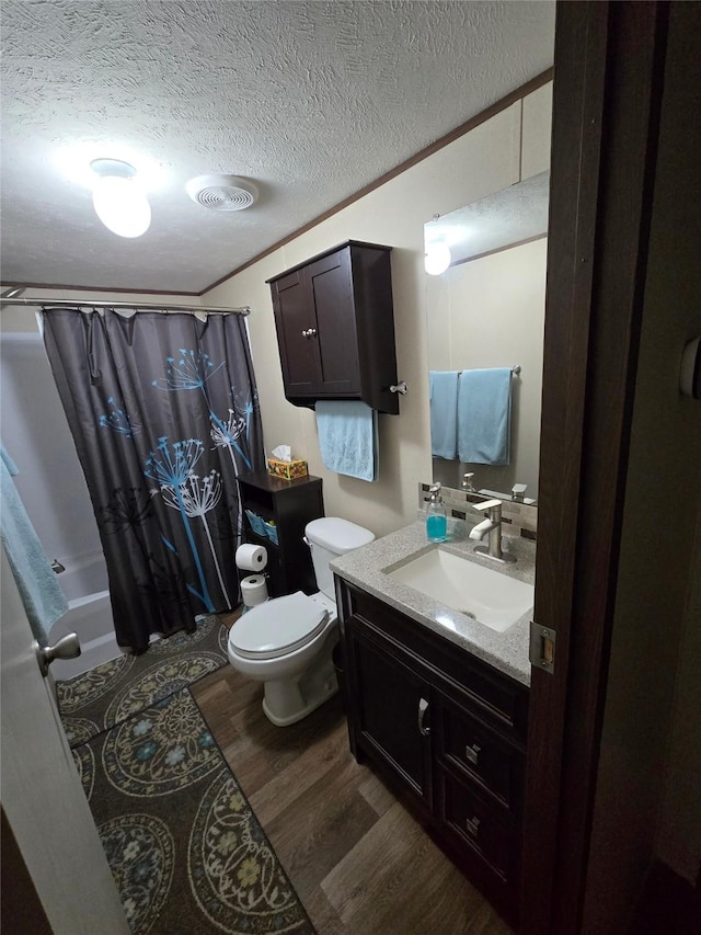 100 St Croix Dr, Point Blank, TX 77364 - full bathroom featuring toilet, wood finished floors, a textured ceiling, vanity, and shower / tub combo with curtain