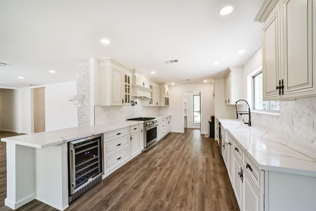 2742 Triway Ln, Houston, TX 77043 - kitchen featuring stainless steel range, wine cooler, a sink, decorative backsplash, and wood finished floors