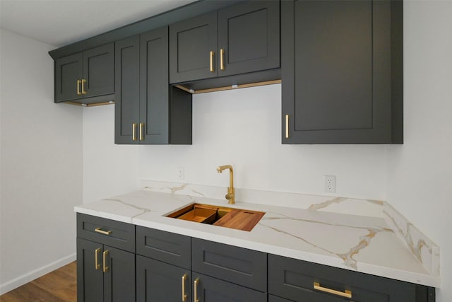 2742 Triway Ln, Houston, TX 77043 - kitchen with a sink, light stone counters, dark wood-style floors, and baseboards