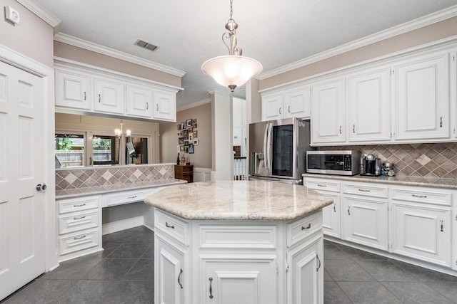 9410 Windrush Dr, Spring, TX 77379 - kitchen featuring appliances with stainless steel finishes, dark tile patterned flooring, white cabinets, decorative backsplash, and ornamental molding