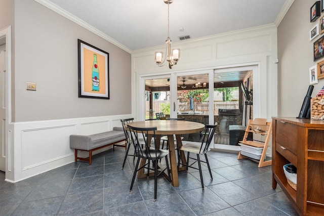 9410 Windrush Dr, Spring, TX 77379 - dining area featuring crown molding, a decorative wall, a chandelier, and a wainscoted wall