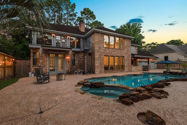 9410 Windrush Dr, Spring, TX 77379 - rear view of house with french doors, a balcony, a chimney, a fenced backyard, and a patio area