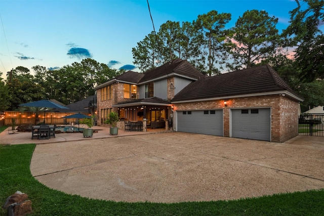 9410 Windrush Dr, Spring, TX 77379 - view of front of property with brick siding, driveway, a garage, and a patio