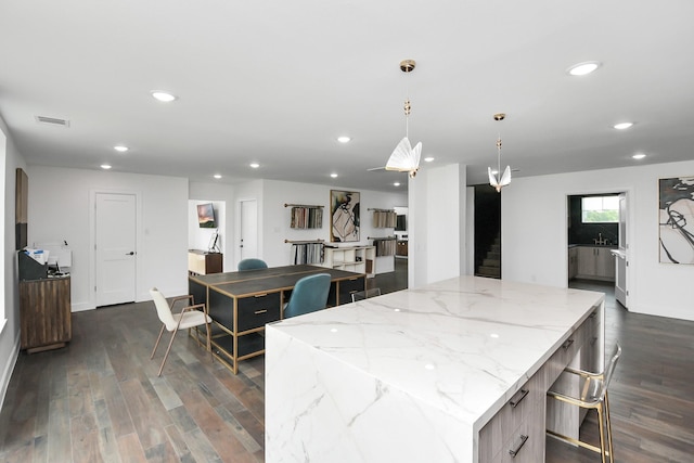 7153 Fm 1458th Rd, Sealy, TX 77474 - kitchen with dark wood-type flooring, a large island, recessed lighting, pendant lighting, and light stone countertops