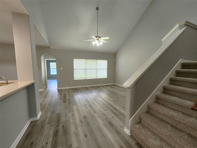 2623 Sable Ridge Ln, Katy, TX 77494 - unfurnished living room with ceiling fan, arched walkways, light wood-style flooring, stairs, and baseboards