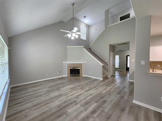 2623 Sable Ridge Ln, Katy, TX 77494 - unfurnished living room with high vaulted ceiling, ceiling fan, light wood-type flooring, stairway, and arched walkways