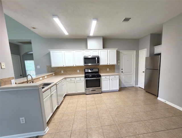 2623 Sable Ridge Ln, Katy, TX 77494 - kitchen with appliances with stainless steel finishes, decorative backsplash, white cabinetry, arched walkways, and light countertops