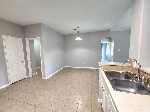 2623 Sable Ridge Ln, Katy, TX 77494 - kitchen featuring a sink, light tile patterned flooring, arched walkways, white cabinets, and hanging light fixtures