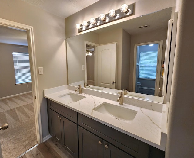 2623 Sable Ridge Ln, Katy, TX 77494 - full bath featuring toilet, double vanity, wood finished floors, baseboards, and ceiling fan