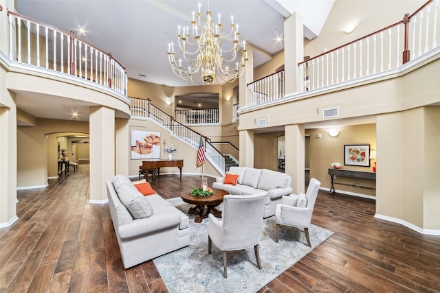 2815 Kings Crossing Dr Unit 106, Houston, TX 77345 - living room with arched walkways, a towering ceiling, stairs, baseboards, and wood finished floors
