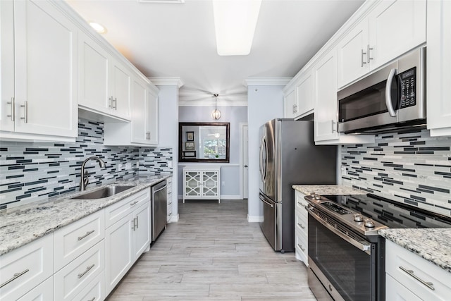 2815 Kings Crossing Dr Unit 106, Houston, TX 77345 - kitchen with appliances with stainless steel finishes, a sink, decorative backsplash, white cabinetry, and crown molding