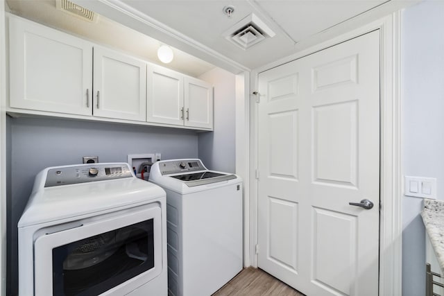 2815 Kings Crossing Dr Unit 106, Houston, TX 77345 - washroom with independent washer and dryer, cabinet space, and light wood-style flooring