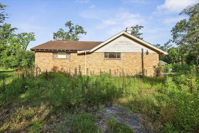 2630 35th St, Pinehurst, TX 77630 - view of side of home featuring brick siding and a chimney