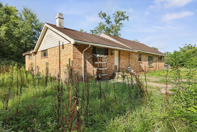 2630 35th St, Pinehurst, TX 77630 - rear view of property with a chimney and brick siding