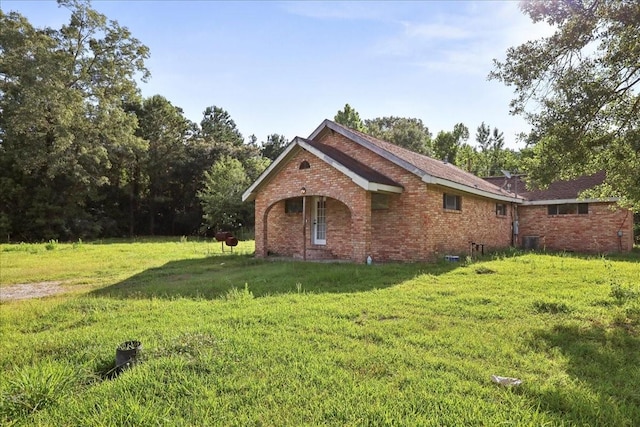 2630 35th St, Pinehurst, TX 77630 - view of side of property featuring brick siding, a yard, and central AC unit
