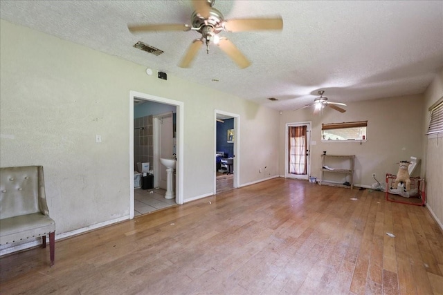 2630 35th St, Pinehurst, TX 77630 - unfurnished living room with a ceiling fan, wood finished floors, a textured ceiling, baseboards, and a sink
