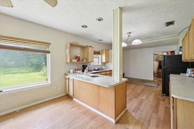 2630 35th St, Pinehurst, TX 77630 - kitchen with a sink, light wood finished floors, a peninsula, a textured ceiling, and light countertops