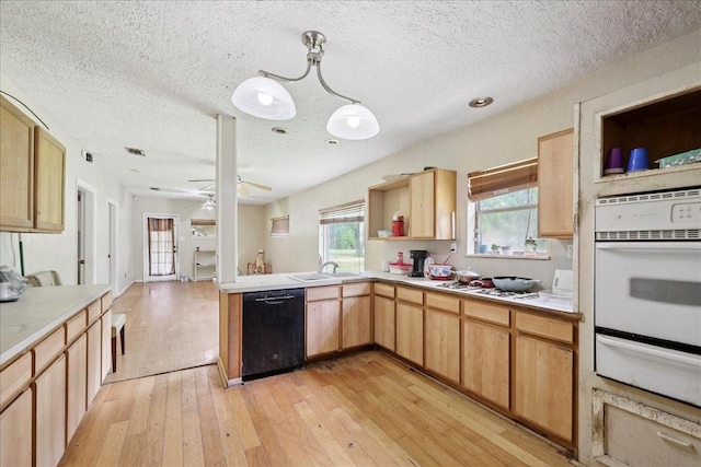 2630 35th St, Pinehurst, TX 77630 - kitchen with white appliances, a warming drawer, light wood-style floors, light countertops, and a textured ceiling