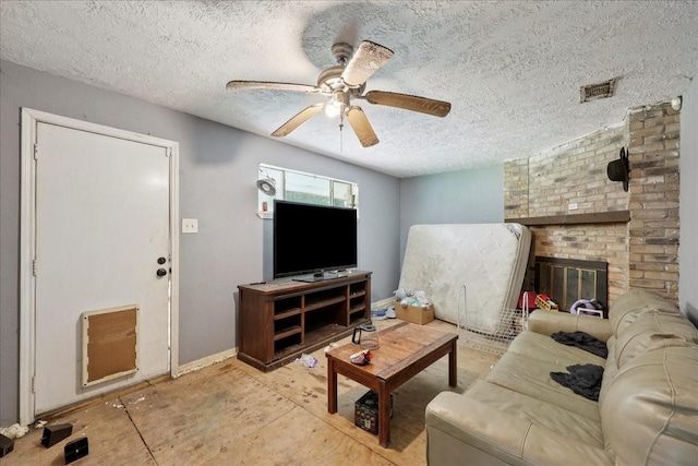 2630 35th St, Pinehurst, TX 77630 - living room featuring a textured ceiling, ceiling fan, baseboards, and a brick fireplace