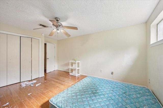 2630 35th St, Pinehurst, TX 77630 - bedroom featuring wood finished floors, a ceiling fan, a textured ceiling, baseboards, and a closet