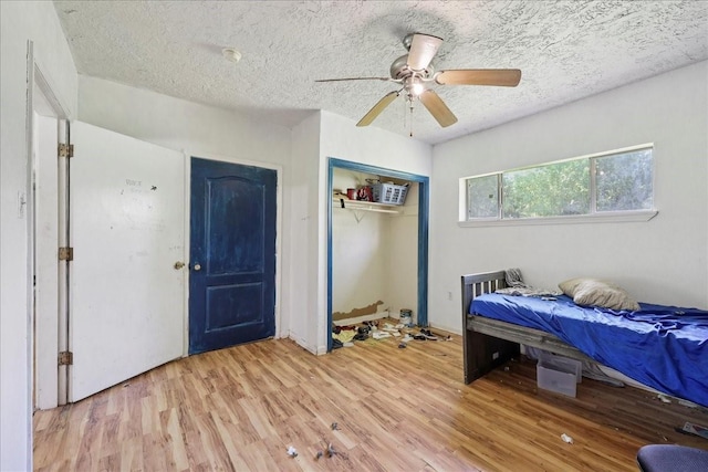 2630 35th St, Pinehurst, TX 77630 - bedroom with light wood-type flooring, a closet, a textured ceiling, and a ceiling fan