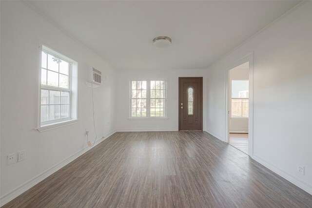 607 Speed St, Wharton, TX 77488 - foyer featuring healthy amount of natural light, wood finished floors, baseboards, and a wall mounted air conditioner