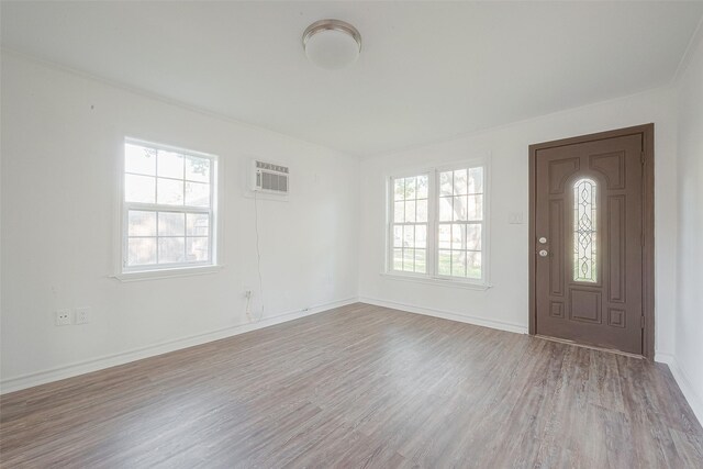 607 Speed St, Wharton, TX 77488 - foyer featuring healthy amount of natural light, a wall mounted AC, wood finished floors, and baseboards
