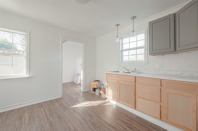 607 Speed St, Wharton, TX 77488 - kitchen featuring light brown cabinetry, light wood-style floors, a sink, backsplash, and gray cabinetry