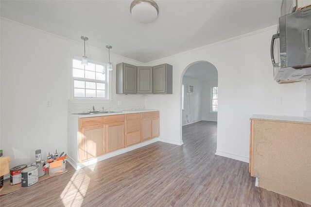 607 Speed St, Wharton, TX 77488 - kitchen featuring arched walkways, ornamental molding, light wood-type flooring, light countertops, and healthy amount of natural light