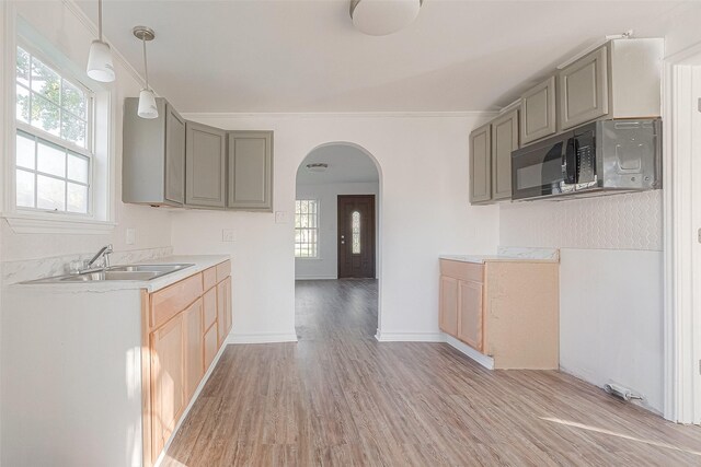 607 Speed St, Wharton, TX 77488 - kitchen with gray cabinetry, arched walkways, light wood-type flooring, a sink, and ornamental molding