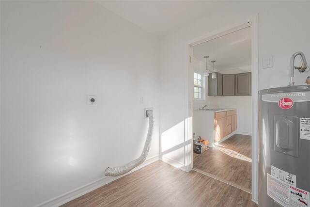 607 Speed St, Wharton, TX 77488 - washroom with electric dryer hookup, wood finished floors, electric water heater, and baseboards