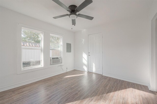 607 Speed St, Wharton, TX 77488 - empty room featuring electric panel, wood finished floors, baseboards, a ceiling fan, and cooling unit