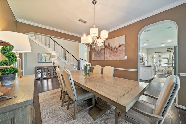 2978 Vintage Park Ln, Pearland, TX 77584 - dining area with stairway, arched walkways, crown molding, a chandelier, and dark wood-type flooring