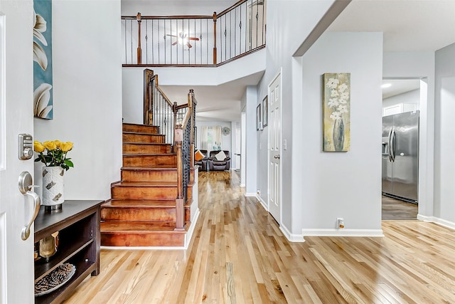 14203 Coveney Dr, Houston, TX 77090 - entryway with stairs, light wood-style floors, baseboards, and a high ceiling
