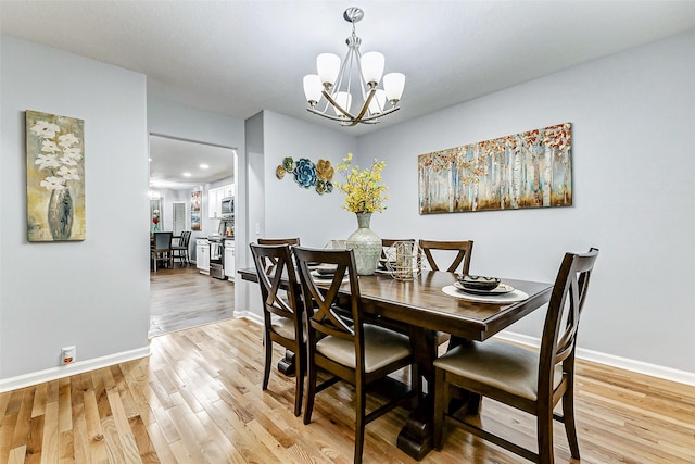 14203 Coveney Dr, Houston, TX 77090 - dining area with a chandelier, light wood-style flooring, and baseboards