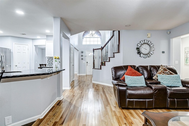 14203 Coveney Dr, Houston, TX 77090 - living area with light wood finished floors, baseboards, stairway, and recessed lighting