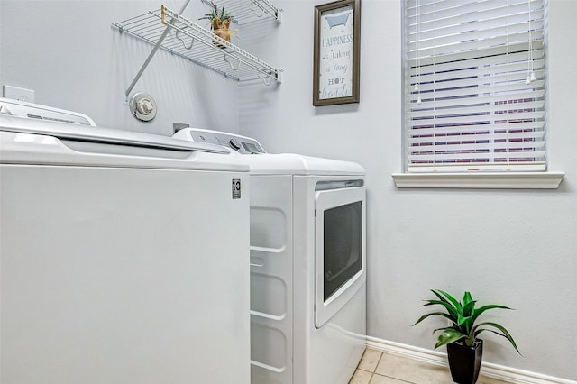 14203 Coveney Dr, Houston, TX 77090 - washroom featuring washing machine and clothes dryer, tile patterned flooring, and baseboards