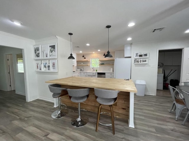 5474 Imogene St, Houston, TX 77096 - kitchen with butcher block counters, freestanding refrigerator, open shelves, baseboards, and recessed lighting
