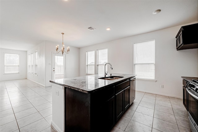 8310 Remington Bluff Ln, Richmond, TX 77407 - kitchen featuring a sink, appliances with stainless steel finishes, light tile patterned floors, stone counters, and a chandelier
