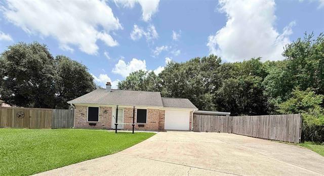9410 Guy Cir, Beaumont, TX 77707 - view of front facade featuring driveway, a garage, and brick siding