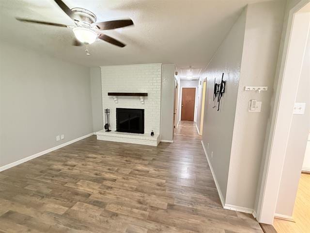 9410 Guy Cir, Beaumont, TX 77707 - unfurnished living room featuring a ceiling fan, a fireplace, wood finished floors, and baseboards