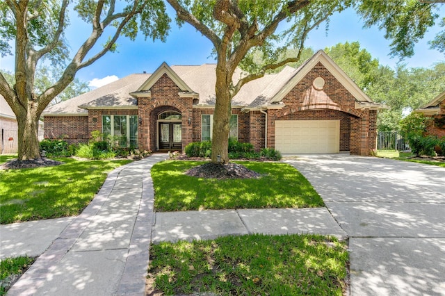 6219 Mound Airy Ct, Sugar Land, TX 77479 - view of front of house with brick siding, french doors, a garage, a front yard, and concrete driveway