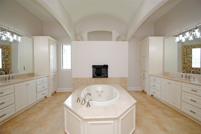 504 High Meadow Ranch Dr, Magnolia, TX 77355 - full bathroom with two vanities, a jetted tub, tile patterned floors, and vaulted ceiling