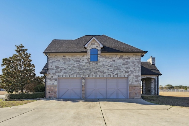 504 High Meadow Ranch Dr, Magnolia, TX 77355 - view of side of property featuring stone siding, driveway, a garage, a chimney, and a shingled roof