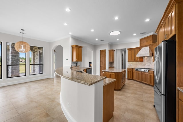 504 High Meadow Ranch Dr, Magnolia, TX 77355 - kitchen featuring appliances with stainless steel finishes, arched walkways, light tile patterned flooring, crown molding, and brown cabinets