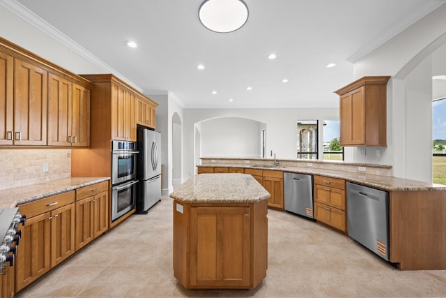 504 High Meadow Ranch Dr, Magnolia, TX 77355 - kitchen with stainless steel appliances, arched walkways, plenty of natural light, ornamental molding, and recessed lighting