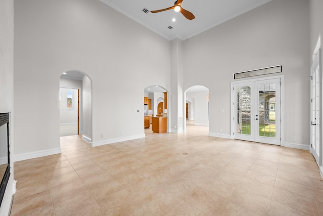 504 High Meadow Ranch Dr, Magnolia, TX 77355 - unfurnished living room featuring ceiling fan, high vaulted ceiling, arched walkways, crown molding, and french doors