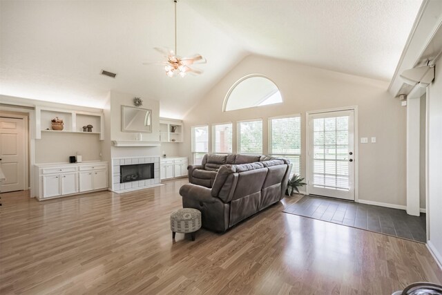 4222 Skylane Rd, Beach City, TX 77523 - living area with wood finished floors, a tiled fireplace, high vaulted ceiling, and baseboards